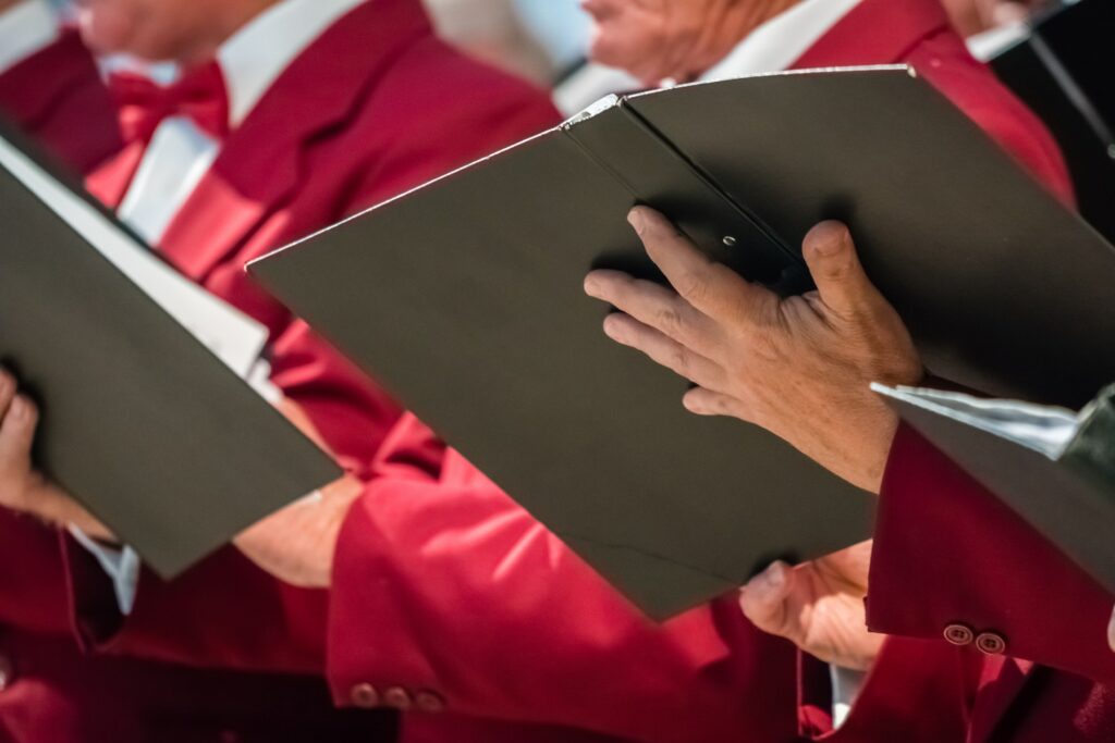 Mens choir members holding singing book